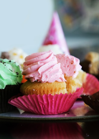 Close-up of colorful, freshly baked cupcakes with vibrant frosting swirls.