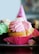 A close-up of a vibrant floral cupcake with thick buttercream frosting in soft pastel colors.