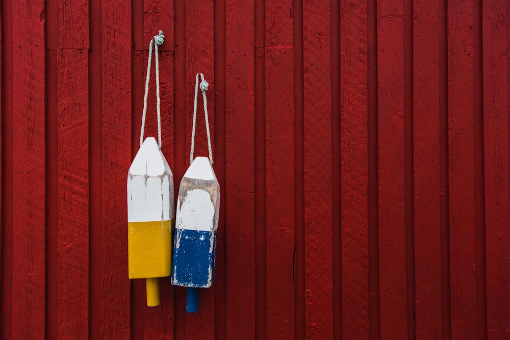 two yellow and blue hanging decors behind red wall