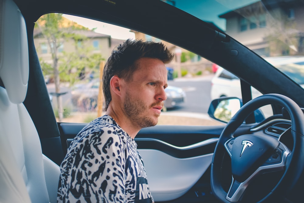 man sitting on car front seat