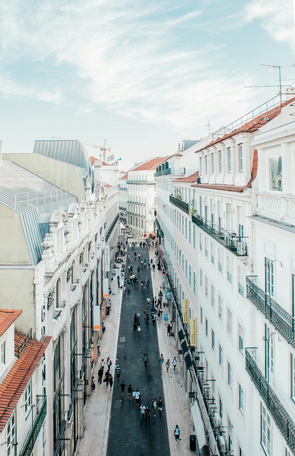 group of people in between white concrete building