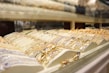A display case filled with various pieces of gold and silver jewelry, including bracelets and necklaces, arranged in an organized fashion under bright lighting.