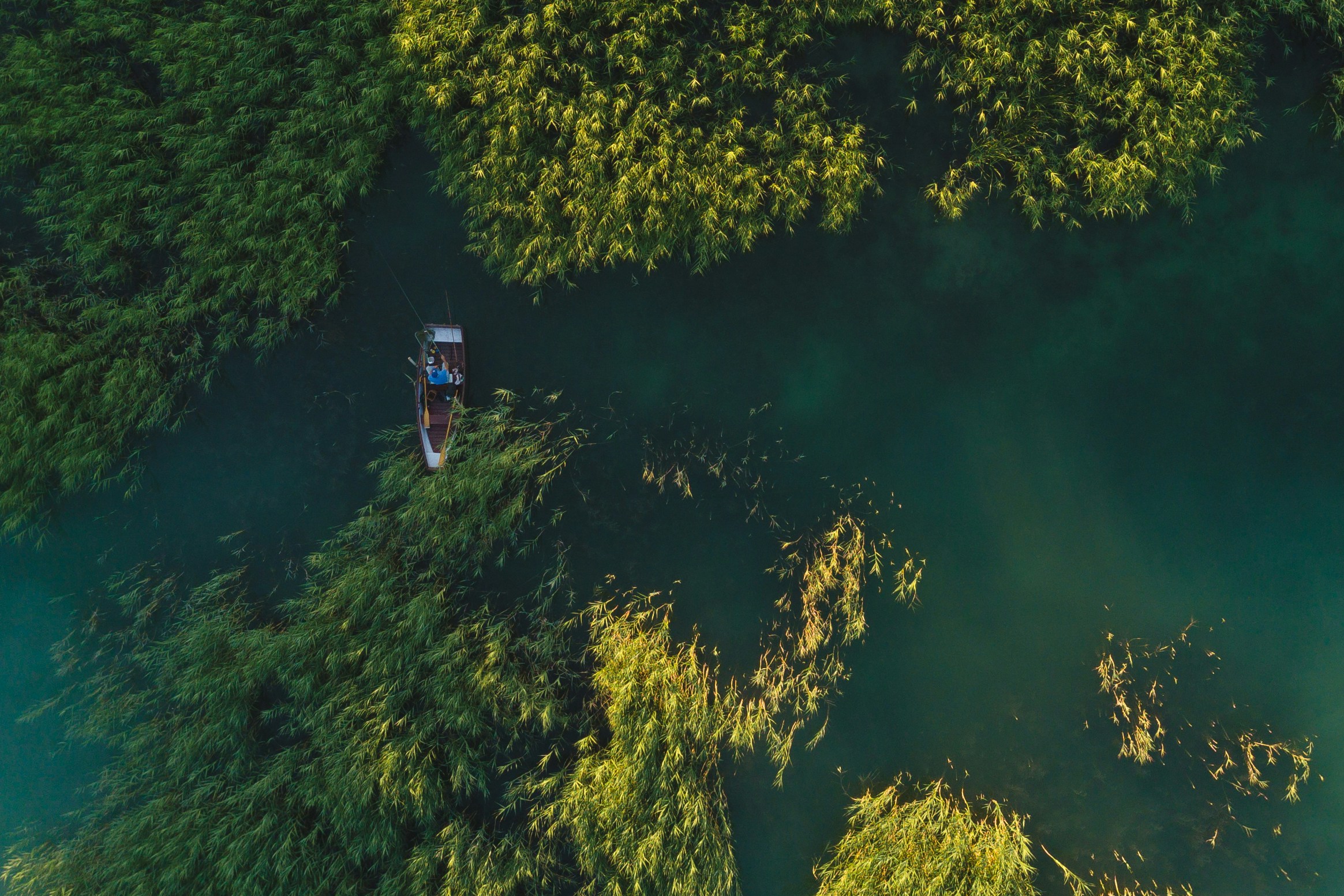 aerial photography of borwn boat on river during daytime drone view teams background