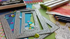 A collection of craft materials including scissors, glue sticks, and colourful paper sheets.