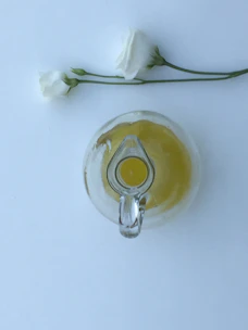 A clean shot of a 5-liter mustard oil container with a backdrop of mustard flowers in bloom.