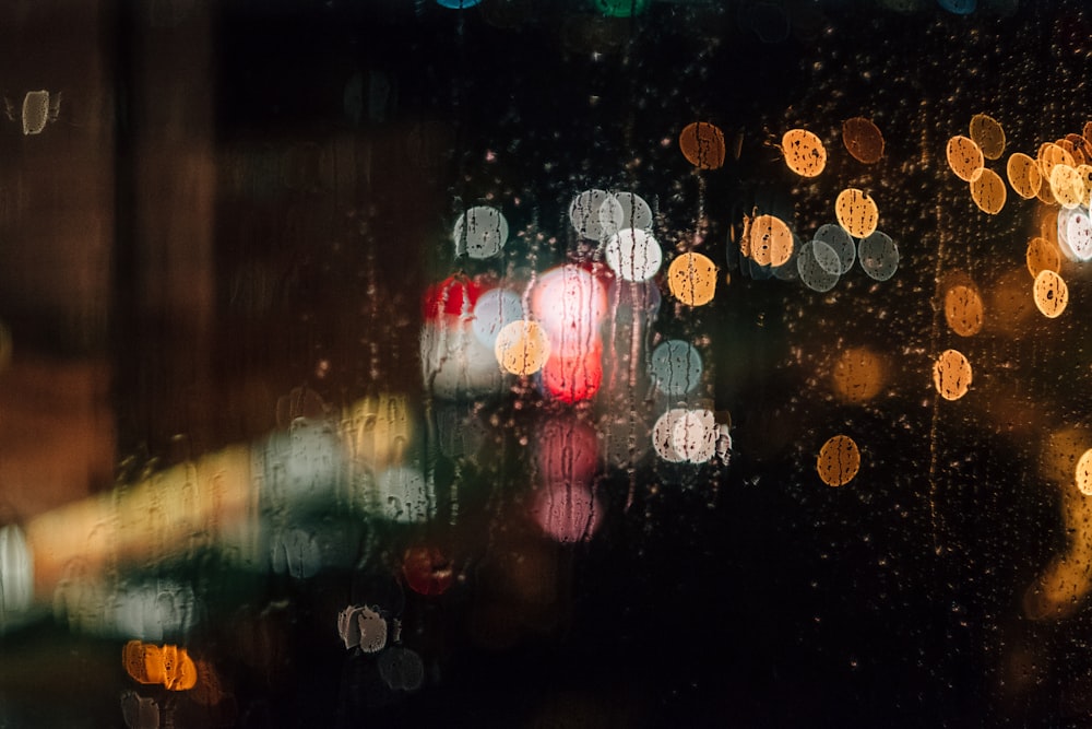 A rain-streaked window with a bokeh effect