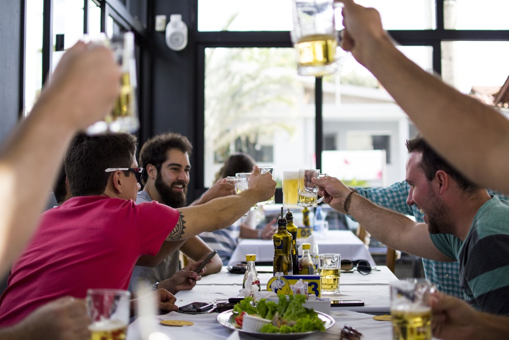 men doing toast beside table