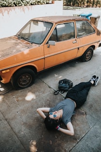 woman lying near the orange vehicle
