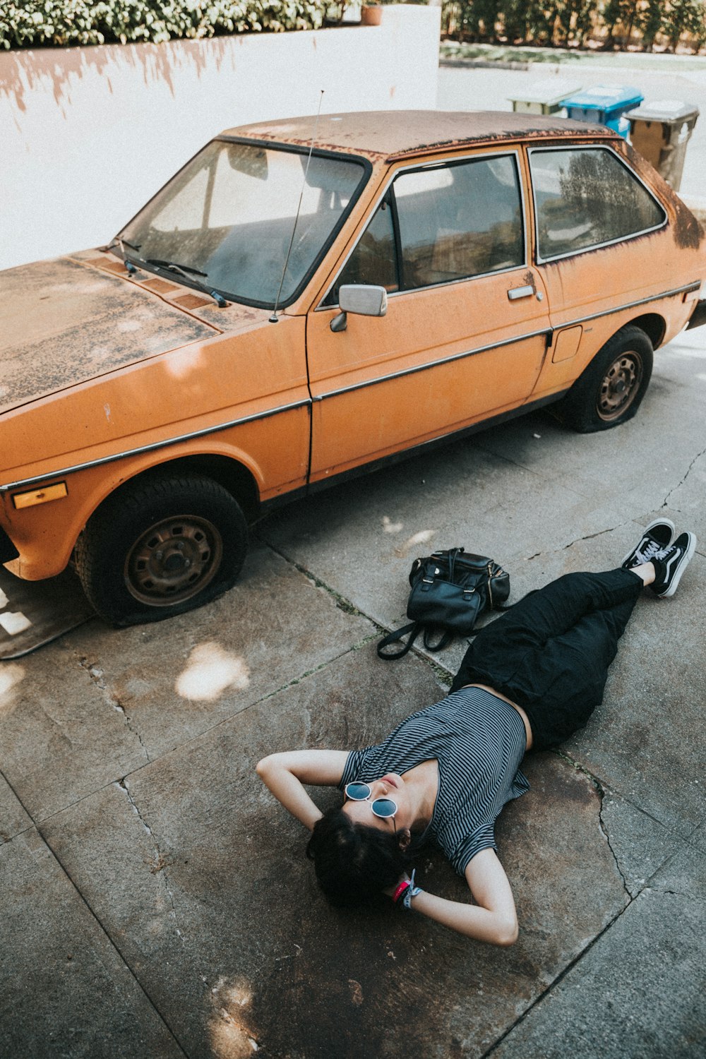 woman lying near the orange vehicle