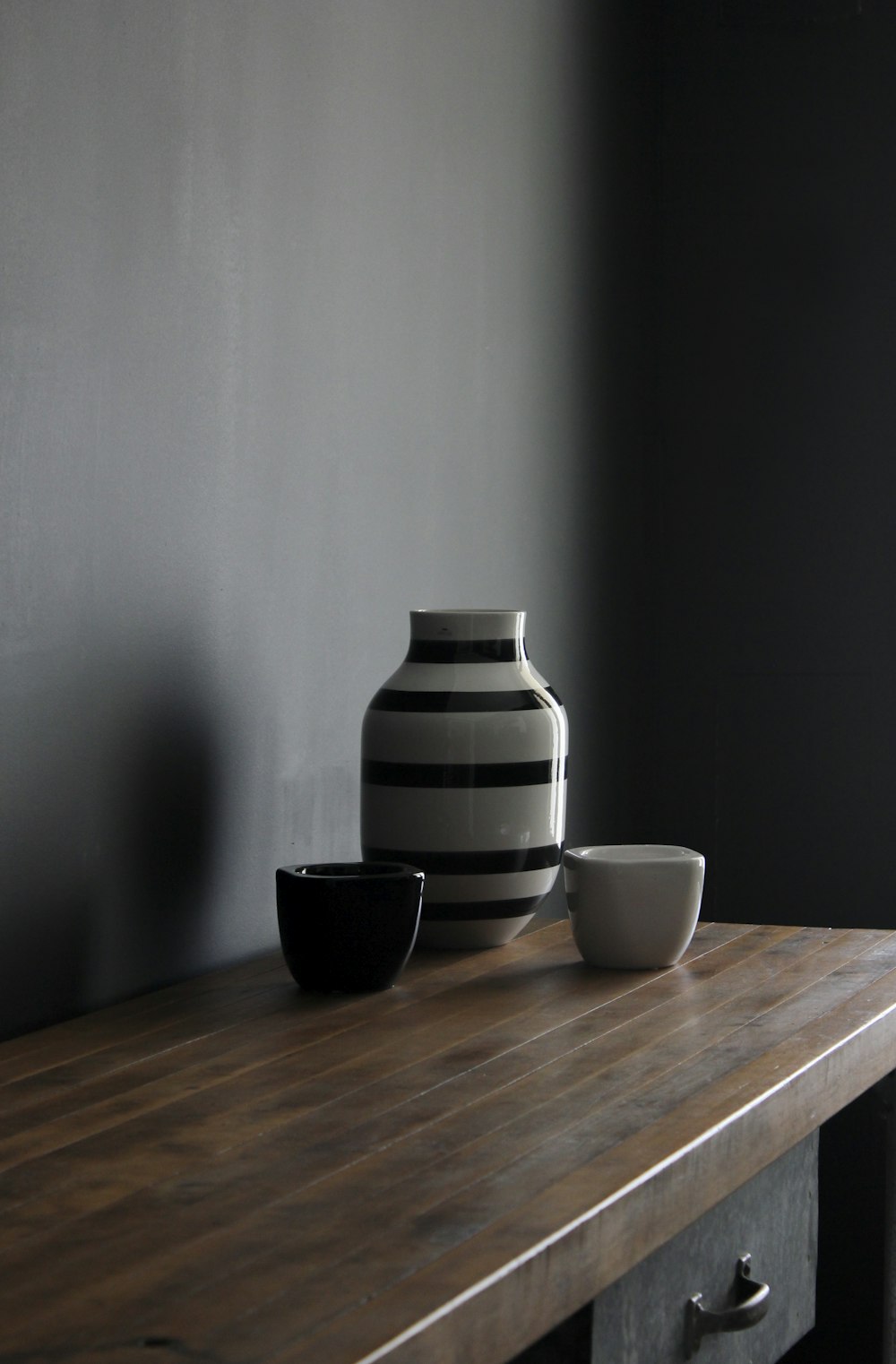 vaso in ceramica a righe bianche e nere su tavolo in legno marrone