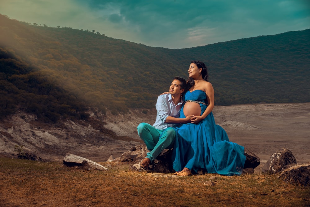 man and woman sitting on brown rock during daytime