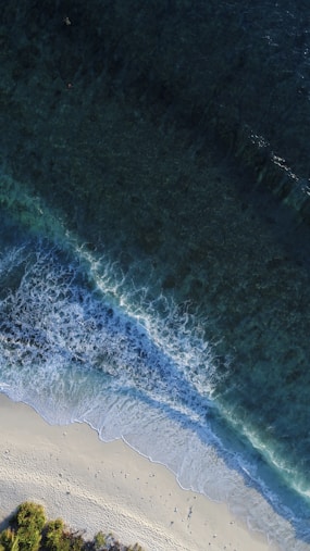turquoise calm sea wave splashing on white sand beach aerial photography
