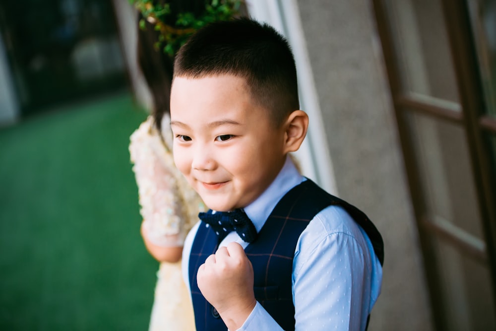 青いチョッキとドレスシャツを着た男の子