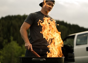 man grilling near white vehicle