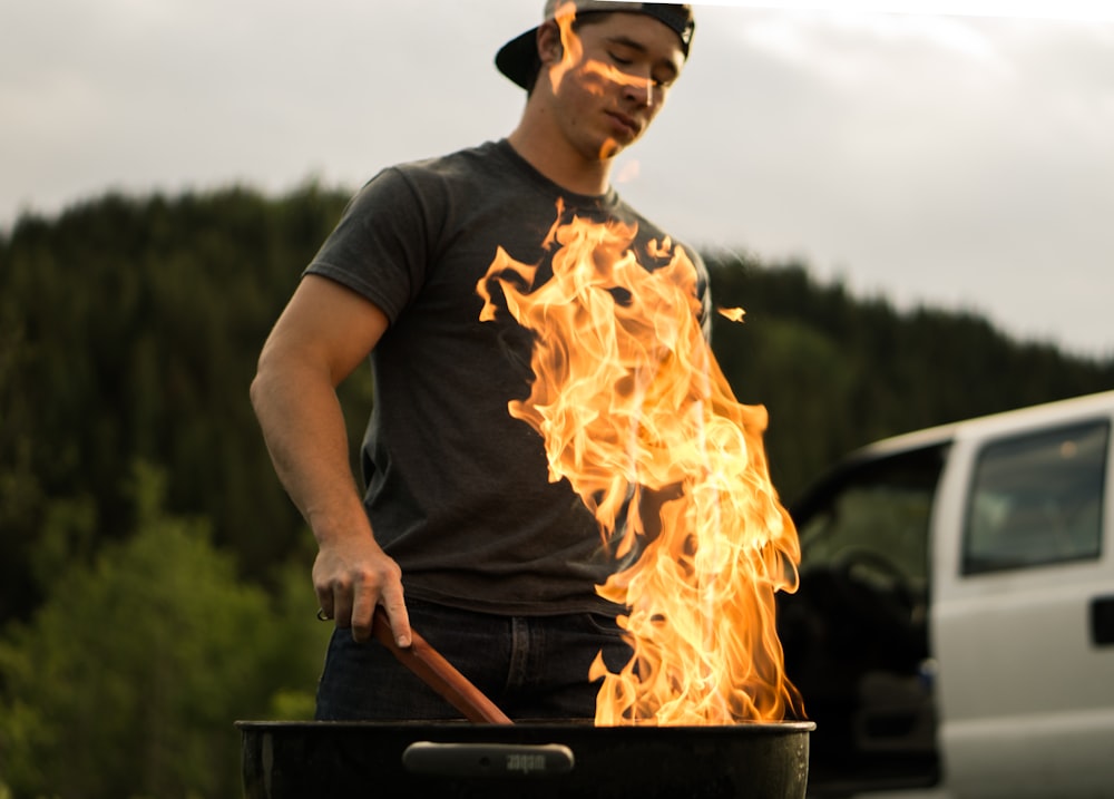 man grilling near white vehicle