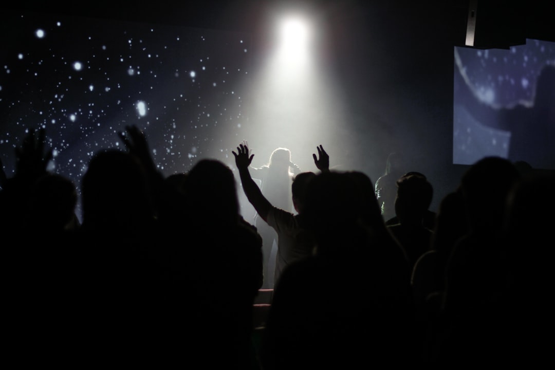 crowd of people inside room dancing while watching person singing