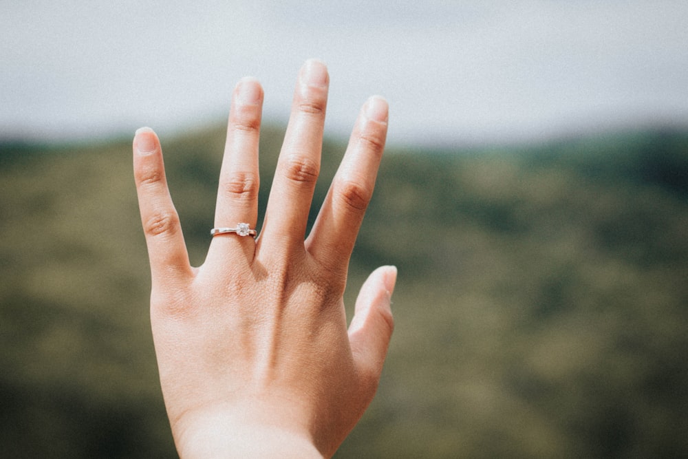 Mujer mostrando su anillo color plata