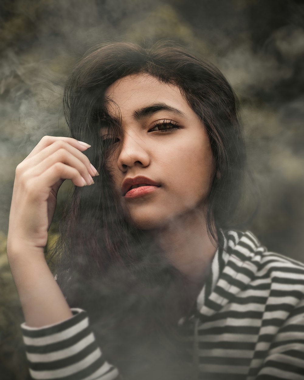 woman in white and black striped pullover top covered with smoke