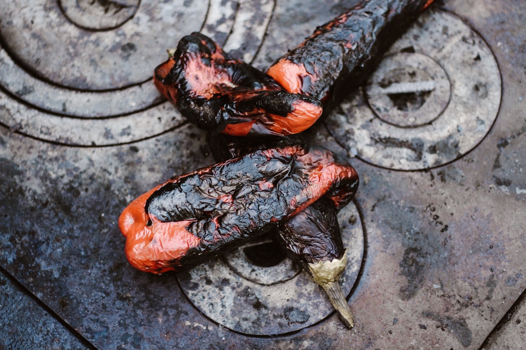 two orange-and-black cooked eggplants on gray stove