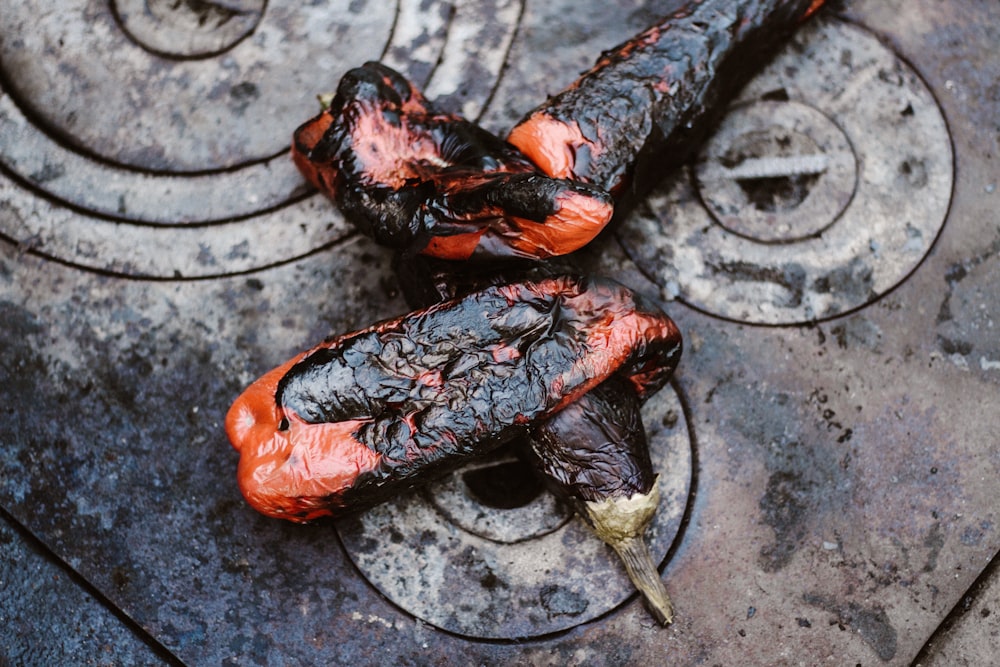 two orange-and-black cooked eggplants on gray stove