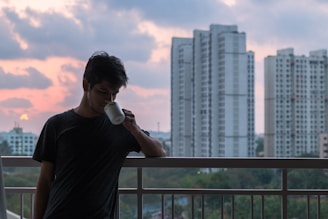 A peaceful morning scene with a resident enjoying coffee on a balcony overlooking the Singapore skyline.