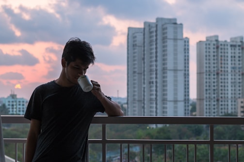 A peaceful morning scene with a resident enjoying coffee on a balcony overlooking the Singapore skyline.