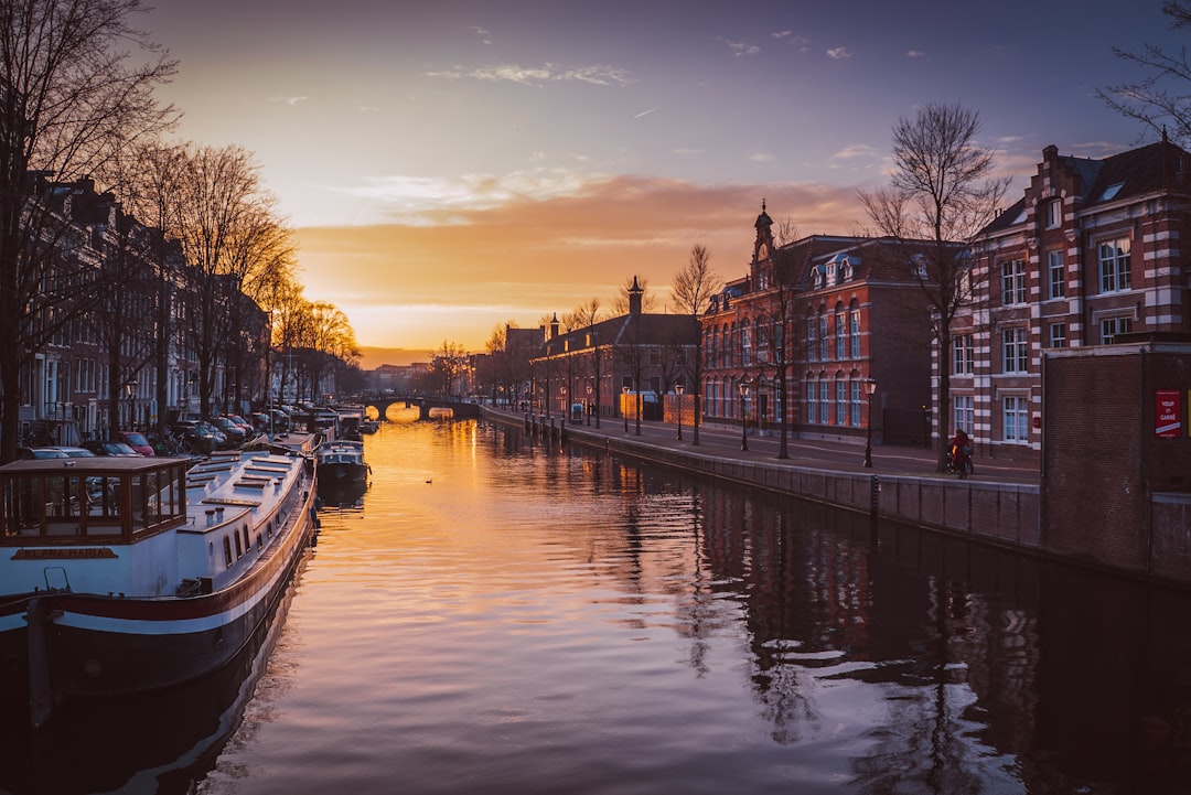 boats on river between buildings, Amsterdam