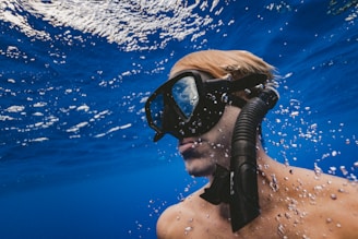 man wearing black goggles under water