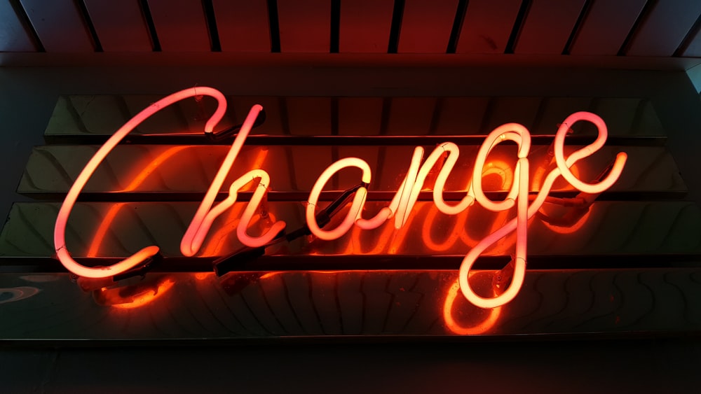 A glowing red â€œchangeâ€ neon on a wall