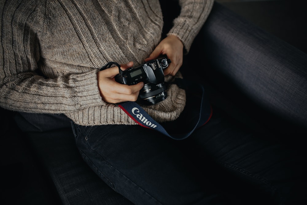 person holding black DSLR camera