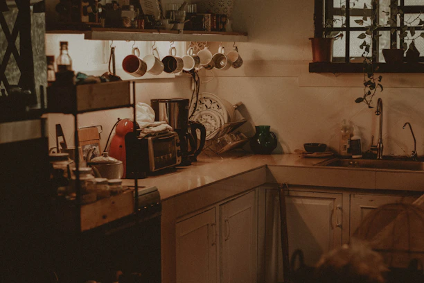 A cozy kitchen corner featuring neatly arranged cleaning tools and home essentials.