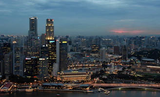 A panoramic view of a modern Iraqi city skyline at dusk, illuminated with vibrant lights symbolizing growth and opportunity.