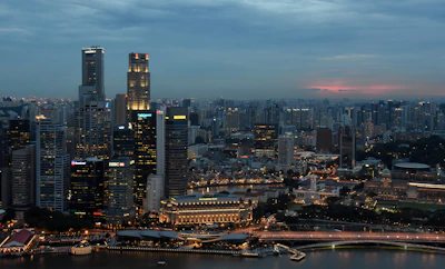 A panoramic view of a modern Iraqi city skyline at dusk, illuminated with vibrant lights symbolizing growth and opportunity.