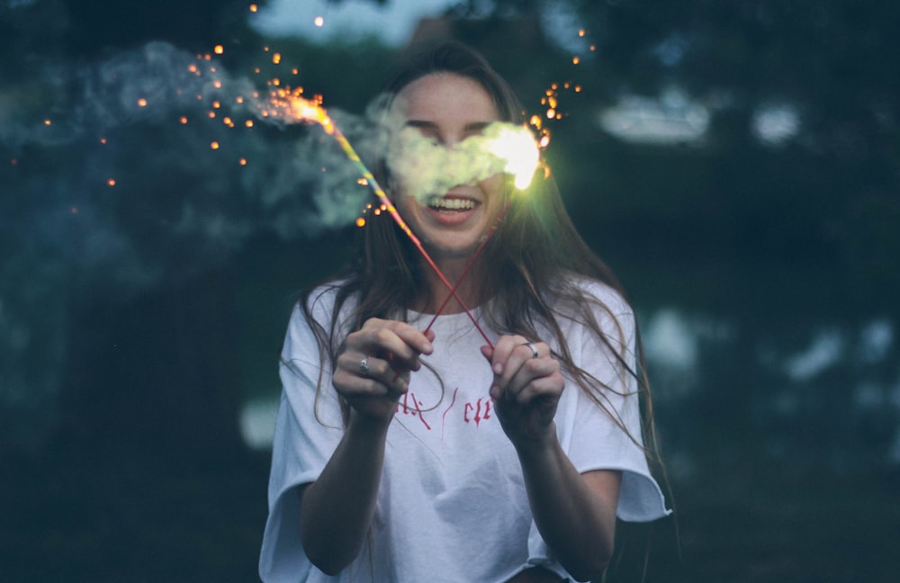 woman holding two sparklers