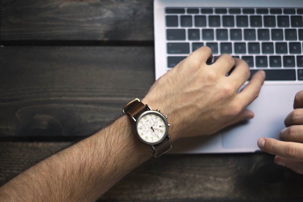 person wearing brown and white watch