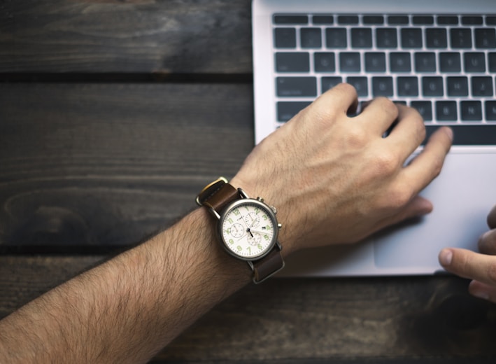 person wearing brown and white watch