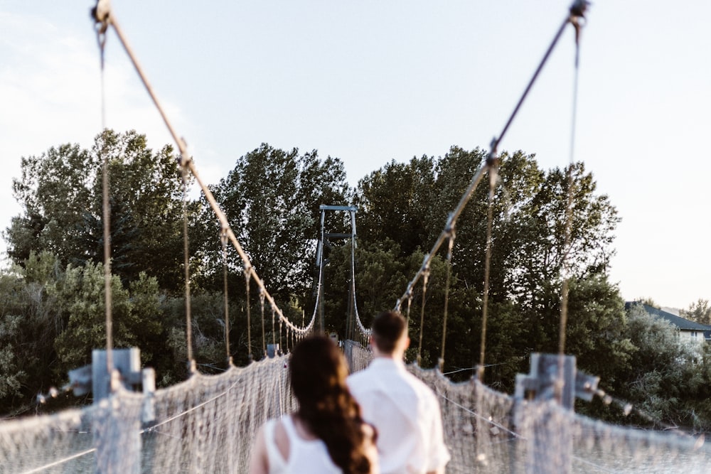 man and woman on suspension bridge