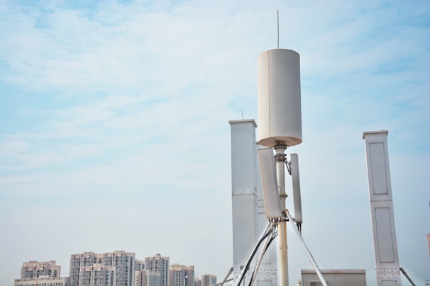 Close-up of a wireless antenna transmitting signals in a cityscape