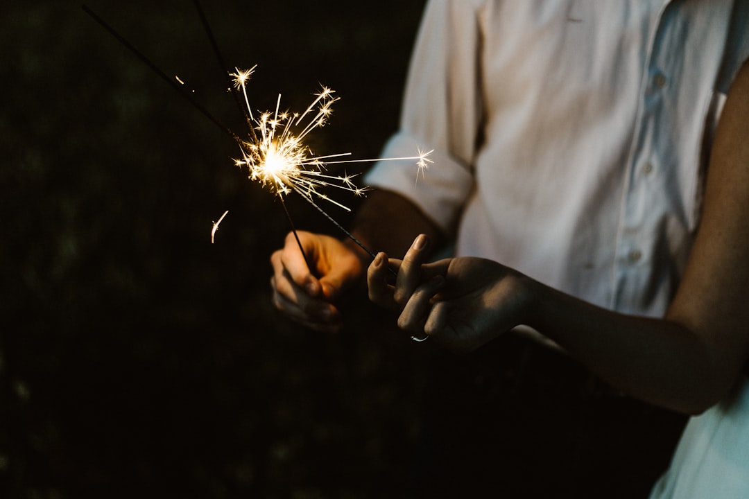 two person holding sparklers