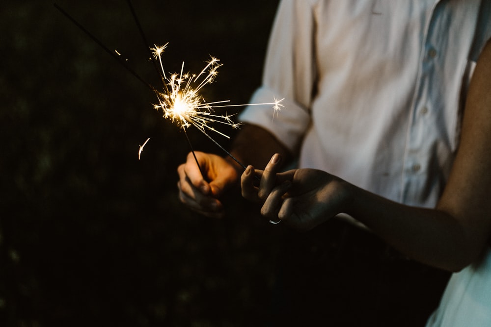 two person holding sparklers