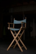 Close-up of a director’s chair with 'emrod labs' logo illuminated in signal orange.