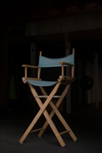 Minimalist shot of a director’s chair and clapperboard against a dark background with soft film grain texture.