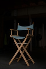 A casting room with a single spotlight illuminating a script resting on a vintage wooden chair.