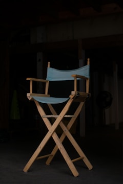 Close-up of a director’s chair with 'emrod labs' logo illuminated in signal orange.