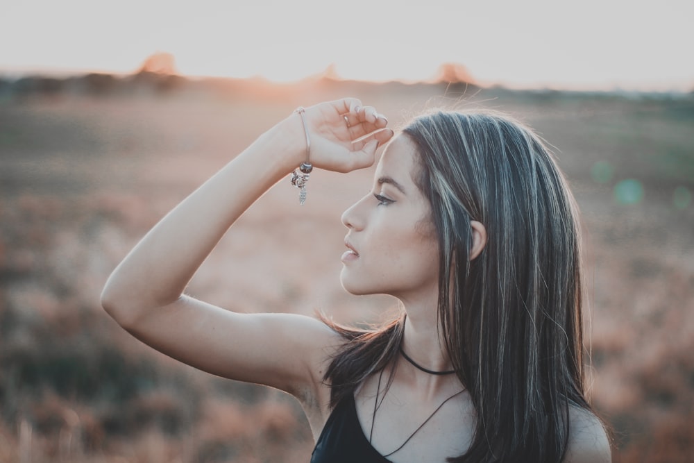 Fotografia de foco raso da mulher no top preto da alça do espaguete