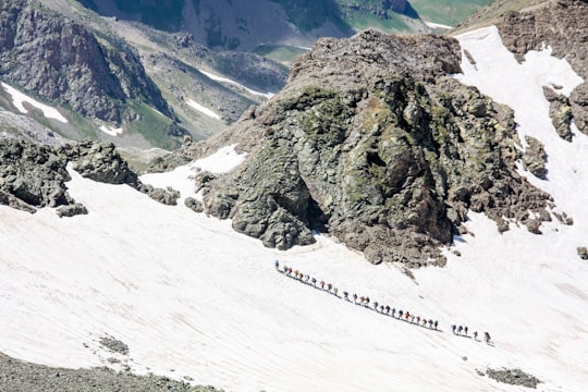 people walking on snow-covered hill beside gray mountain in Arkhyz Russia