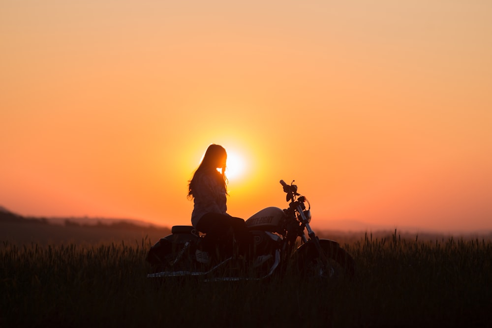 woman riding cruiser motorcycle during golden hour