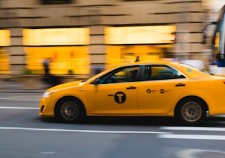 tilt shift photography of yellow taxi car