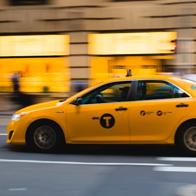 tilt shift photography of yellow taxi car