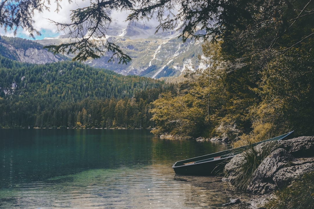 blue boat docked near the rock, Lago di Tovel mountain lake